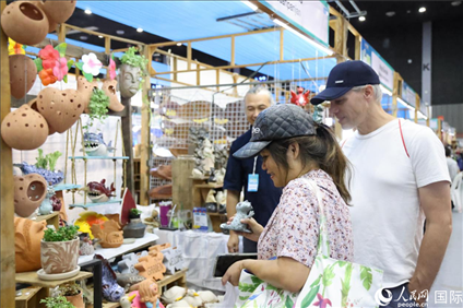 游客在蘭納博覽會(huì)特色展位上選購(gòu)工藝品。人民網(wǎng)記者楊一攝