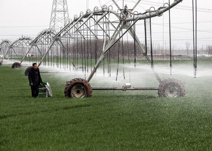 2024年3月18日，在河南省焦作市博愛縣孝敬鎮(zhèn)東原莊村瑞輝家庭農(nóng)場，村民使用全自動指針式噴灌機進行澆灌作業(yè)。新華社發(fā)（程全攝）