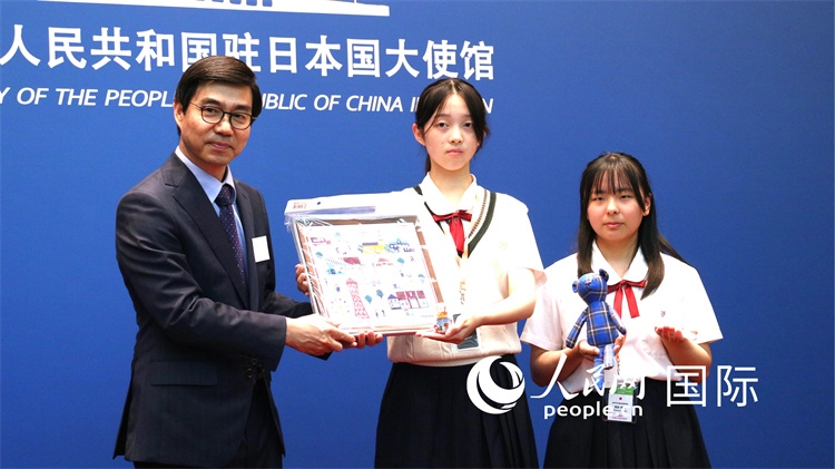 日本小大使向中國駐日本大使館臨時代辦施泳贈送當?shù)靥厣Y品。人民網(wǎng) 許可攝