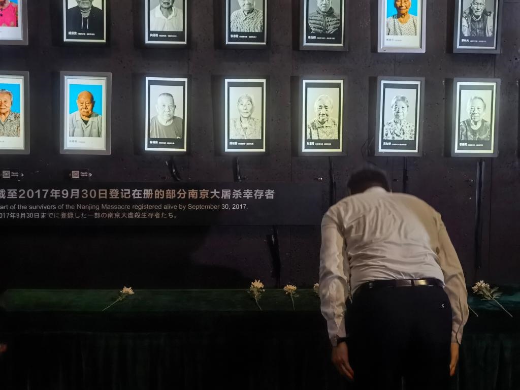 7月18日，人們向離世的南京大屠殺幸存者獻(xiàn)花、鞠躬。新華社記者邱冰清 攝