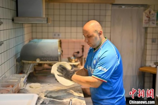 近日，韋榮耀在自家披薩小店內(nèi)忙活。俞靖 攝