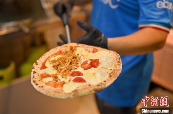 近日，韋榮耀展示他制作的“老友味”披薩。 俞靖 攝
