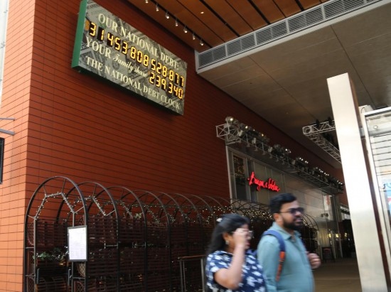 2023年5月29日，人們經(jīng)過(guò)美國(guó)紐約曼哈頓的“國(guó)債鐘”?！皣?guó)債鐘”是一個(gè)大型計(jì)數(shù)器，它實(shí)時(shí)更新美國(guó)的公共債務(wù)總額，并顯示出每個(gè)美國(guó)家庭所要負(fù)擔(dān)的數(shù)額。 新華社記者劉亞南攝