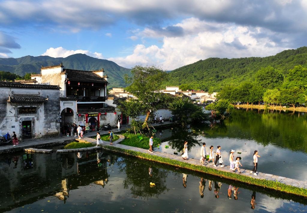 2024年7月7日，游客在安徽省黃山市黟縣宏村游玩。新華社記者杜宇攝