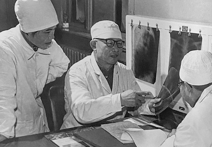 1980年1月16日，中日友好醫(yī)院首任院長辛育齡（中）在內(nèi)蒙古結(jié)核病院與胸外科醫(yī)師討論病例（翻拍照片）。 新華社發(fā)