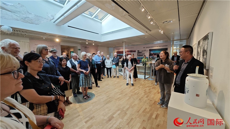 參展人、景德鎮(zhèn)陶瓷大學(xué)美術(shù)學(xué)院副院長(zhǎng)邵長(zhǎng)宗（右一）向來(lái)賓介紹參展作品。人民網(wǎng)記者 殷淼攝