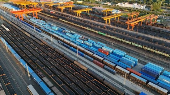 這是2024年8月14日在黑龍江綏芬河鐵路口岸集裝箱換裝場拍攝的集裝箱換裝作業(yè)現(xiàn)場（無人機照片）。今年前七個月，綏芬河鐵路口岸開行中歐班列573列，運量達55246標箱，同比分別增長23%和18%，班列數(shù)量持續(xù)保持高位運行。