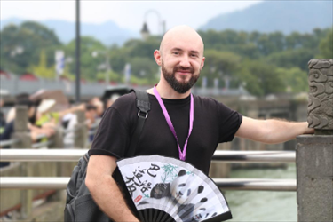 俄羅斯塔斯社執(zhí)行編輯葉夫根尼·扎多羅日內(nèi)在都江堰魚嘴拍照留念。（李佩藺 攝）