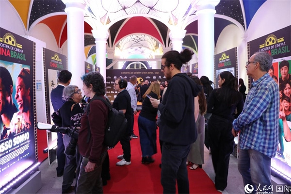為期4天的第三屆中國(guó)－巴西電影展期間，來(lái)自中巴兩國(guó)的14部參展影片受到巴西電影愛(ài)好者和社會(huì)各界人士好評(píng)，圖為當(dāng)?shù)赜^眾在影展舉辦地巴西里約熱內(nèi)盧勞拉—阿爾維姆文化之家的迎賓廳欣賞參展電影海報(bào)。 人民網(wǎng)記者 陳一鳴攝