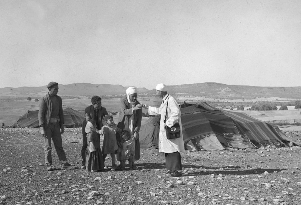 1965年，一名中國援阿爾及利亞醫(yī)療隊醫(yī)生（右一）在阿爾及利亞賽伊達省為牧民診治。