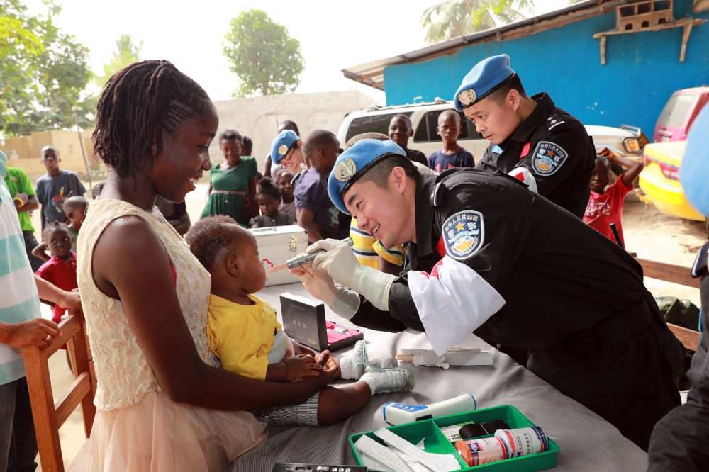 2017年12月28日，在利比里亞蒙羅維亞，中國(guó)維和警察防暴隊(duì)醫(yī)療人員為兒童做口腔檢查。