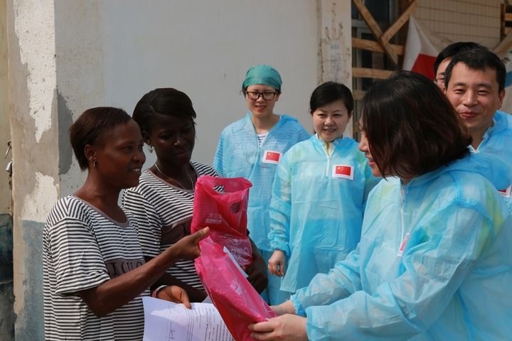 2015年4月4日，在位于塞拉利昂首都弗里敦市郊的中塞友好醫(yī)院埃博拉診療中心，中國(guó)第四批援塞醫(yī)療隊(duì)副隊(duì)長(zhǎng)邵蔚（右前）向被治愈的埃博拉出血熱患者贈(zèng)送禮物。新華社發(fā)（祖榮強(qiáng) 攝）