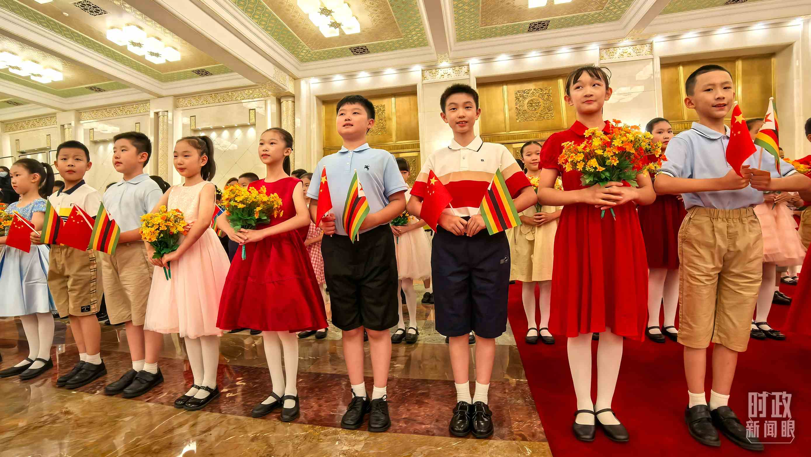 △現(xiàn)場歡迎津巴布韋總統(tǒng)訪華的青少年。（總臺央視記者鐘銳拍攝）