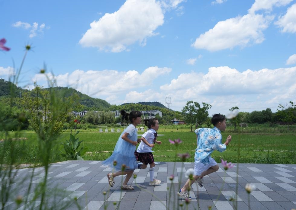 兒童在余姚市梁弄鎮(zhèn)的田野間奔跑（7月3日攝）。新華社記者翁忻旸 攝