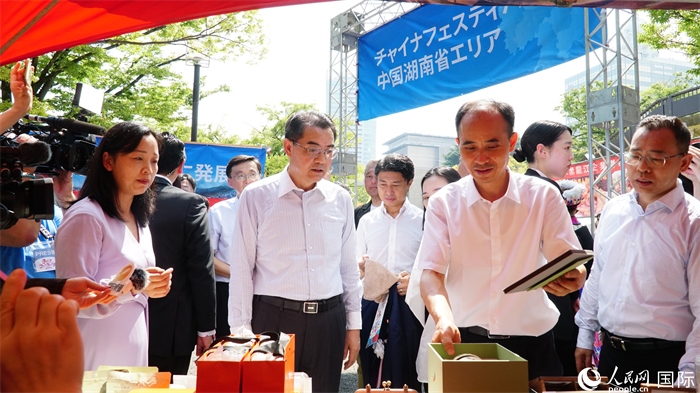 湖南展位工作人員向中國駐日本大使吳江浩介紹特色文創(chuàng)產(chǎn)品。人民網(wǎng) 蔣曉辰攝