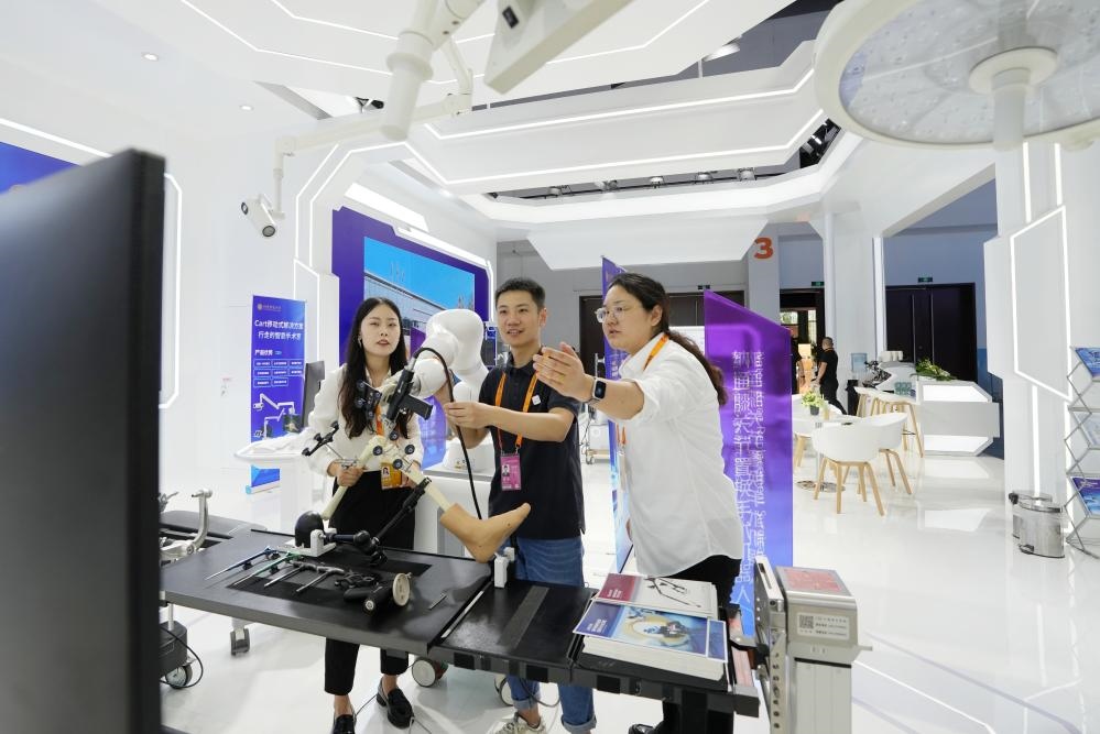 9月11日，一位媒體記者（中）在2024年服貿(mào)會(huì)國(guó)家會(huì)議中心會(huì)場(chǎng)體驗(yàn)北京納通科技集團(tuán)有限公司的膝關(guān)節(jié)置換手術(shù)機(jī)器人。新華社記者鞠煥宗 攝