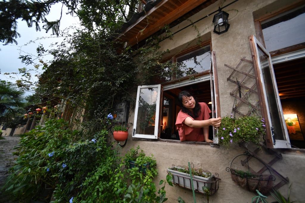 8月29日，在福建省屏南縣熙嶺鄉(xiāng)，龍?zhí)洞濉靶麓迕瘛泵泛暝诖蚶碜约航?jīng)營的民宿外墻裝飾花盆。新華社記者姜克紅 攝