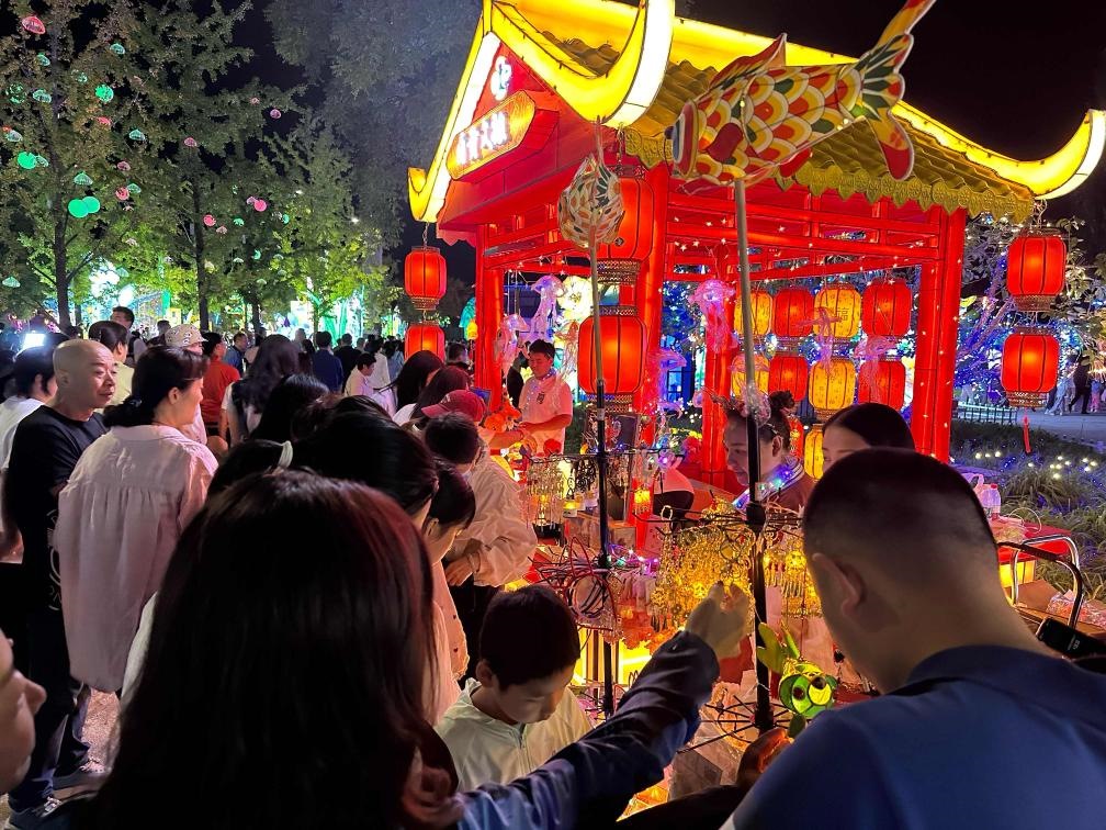 市民游客在2024年北京中秋國(guó)慶彩燈游園會(huì)上選購(gòu)特色文創(chuàng)商品。新華社記者楊淑君 攝