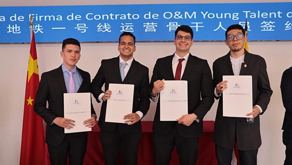 當?shù)貢r間9月13日，40名哥倫比亞青年與中企承建運營的波哥大地鐵一號線項目簽約，不久將前往中國進行為期15個月的專業(yè)地鐵知識培訓。圖為部分學員在簽約儀式上展示所簽的協(xié)議。 波哥大地鐵一號線項目供圖