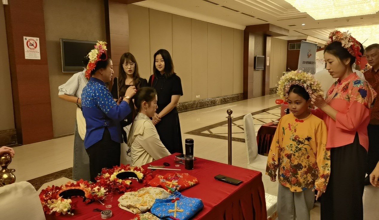 阿拉扎大學(xué)孔子學(xué)院志愿者老師向傳承人學(xué)習(xí)簪花圍。阿拉扎大學(xué)孔子學(xué)院供圖