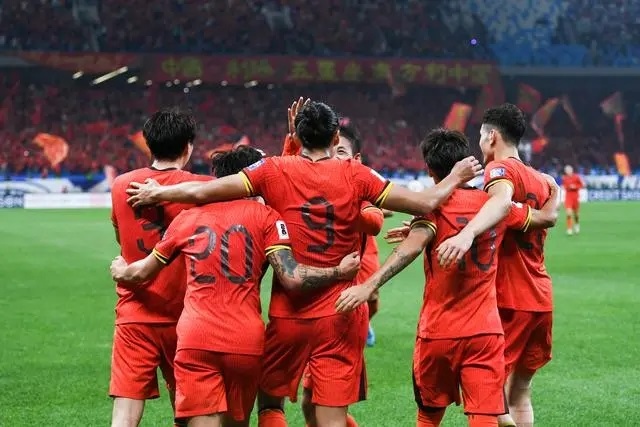 10月15日晚，張玉寧（9號）進(jìn)球后與隊友擁抱慶祝。新華社記者 李紫恒攝