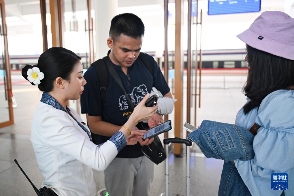10月12日，在老撾萬象中老鐵路萬象站，工作人員檢驗乘客車票。新華社記者 程一恒 攝