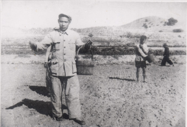 谷文昌（左）在田間與農(nóng)民一起勞動(dòng)（資料照片）。