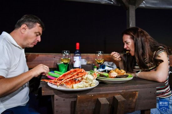 9月2日，食客們?cè)诙砹_斯符拉迪沃斯托克的一家餐館品嘗帝王蟹。新華社記者 曹陽(yáng) 攝
