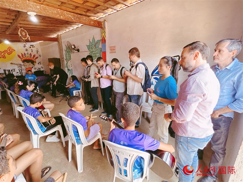  受益于中國企業(yè)的“青少年成長”項目，700多名當(dāng)?shù)厍嗌倌甑囊魳泛妥闱驂粝氩迳狭顺岚?。圖為聯(lián)合采訪團(tuán)正在采訪參加音樂培訓(xùn)的孩子們。 人民網(wǎng)記者 陳一鳴攝