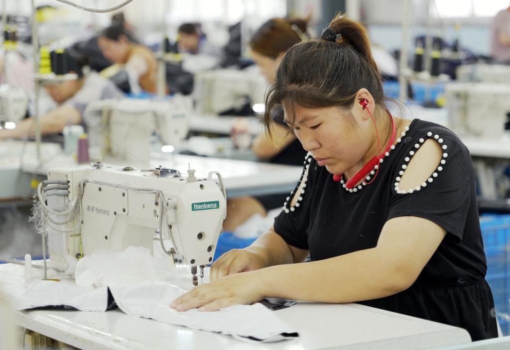 5月20日，村民在李寨村服裝加工廠內(nèi)忙碌。河南省周口市沈丘縣馮營鎮(zhèn)李寨村地處豫東平原。近年來，乘著脫貧攻堅與鄉(xiāng)村振興政策的東風，李寨村積極探索產(chǎn)業(yè)發(fā)展模式，通過“龍頭企業(yè)+村集體經(jīng)濟+農(nóng)戶”的方式，逐漸發(fā)展形成肉牛養(yǎng)殖、設施農(nóng)業(yè)、服裝加工、康養(yǎng)民宿等產(chǎn)業(yè)，以產(chǎn)業(yè)振興助力鄉(xiāng)村振興。新華社記者 李嘉南 攝