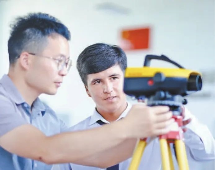 在塔吉克斯坦首都杜尚別的魯班工坊，來自天津城市建設(shè)管理職業(yè)技術(shù)學(xué)院的老師（左）為當(dāng)?shù)貙W(xué)生提供指導(dǎo)。新華社記者 鄭開君 攝