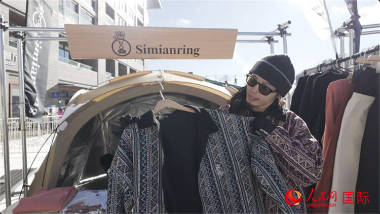 藤田周正在展示自己設(shè)計的滑雪服。人民網(wǎng)記者 袁蒙攝