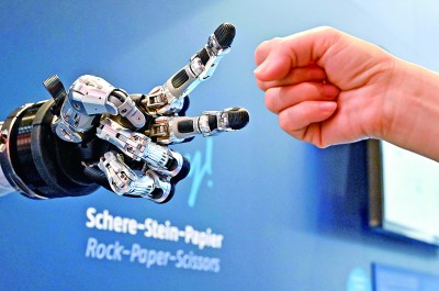 在德國(guó)漢諾威工博會(huì)上，參觀者與一款智能機(jī)器人進(jìn)行“石頭剪子布”游戲。新華社發(fā)