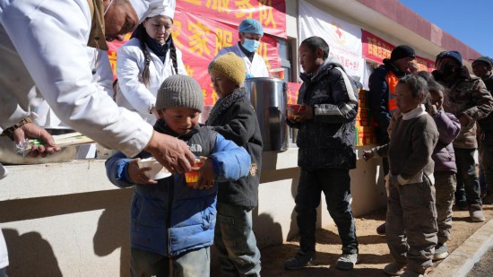 1月14日，廚師們正在給前來用餐的小朋友們打飯。新華社記者 邱星翔 攝