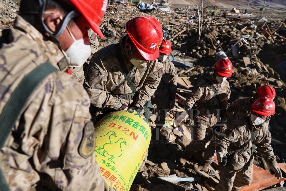 1月10日，定日縣長所鄉(xiāng)古榮村，武警官兵幫助受災群眾整理廢墟，搶救被掩埋的物資。環(huán)球時報記者崔萌攝