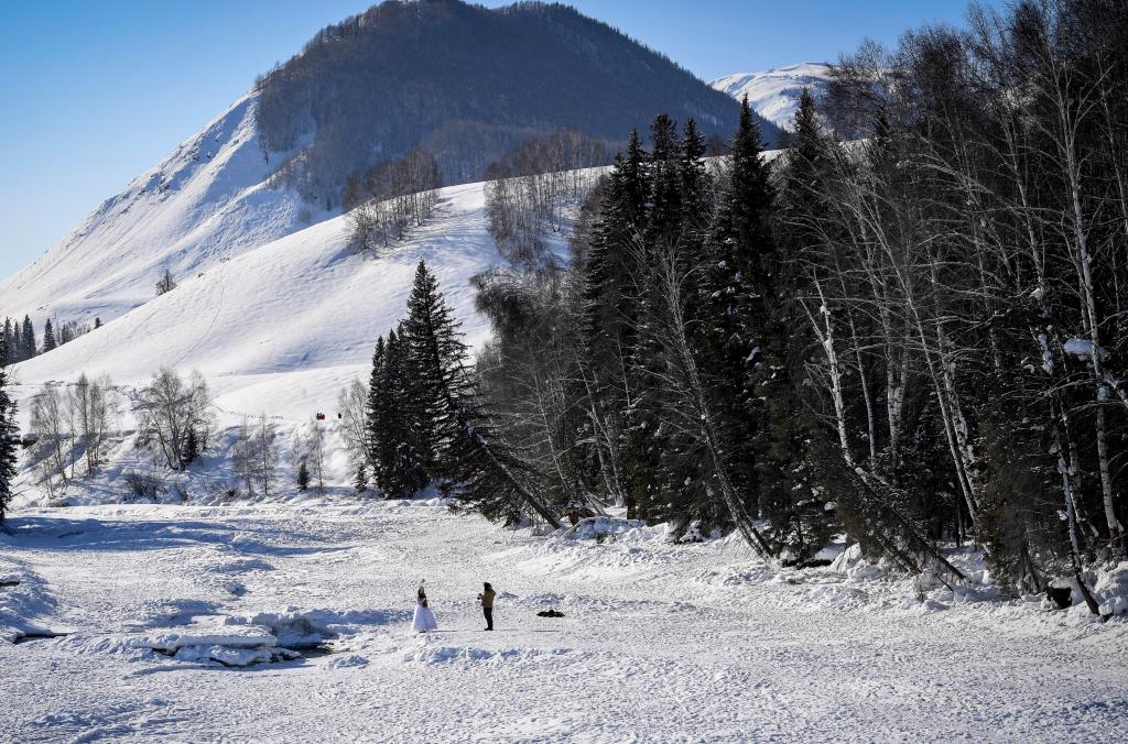 2024年2月5日，兩名游客在新疆阿勒泰地區(qū)布爾津縣禾木村拍照。新華社記者 馬鍇 攝