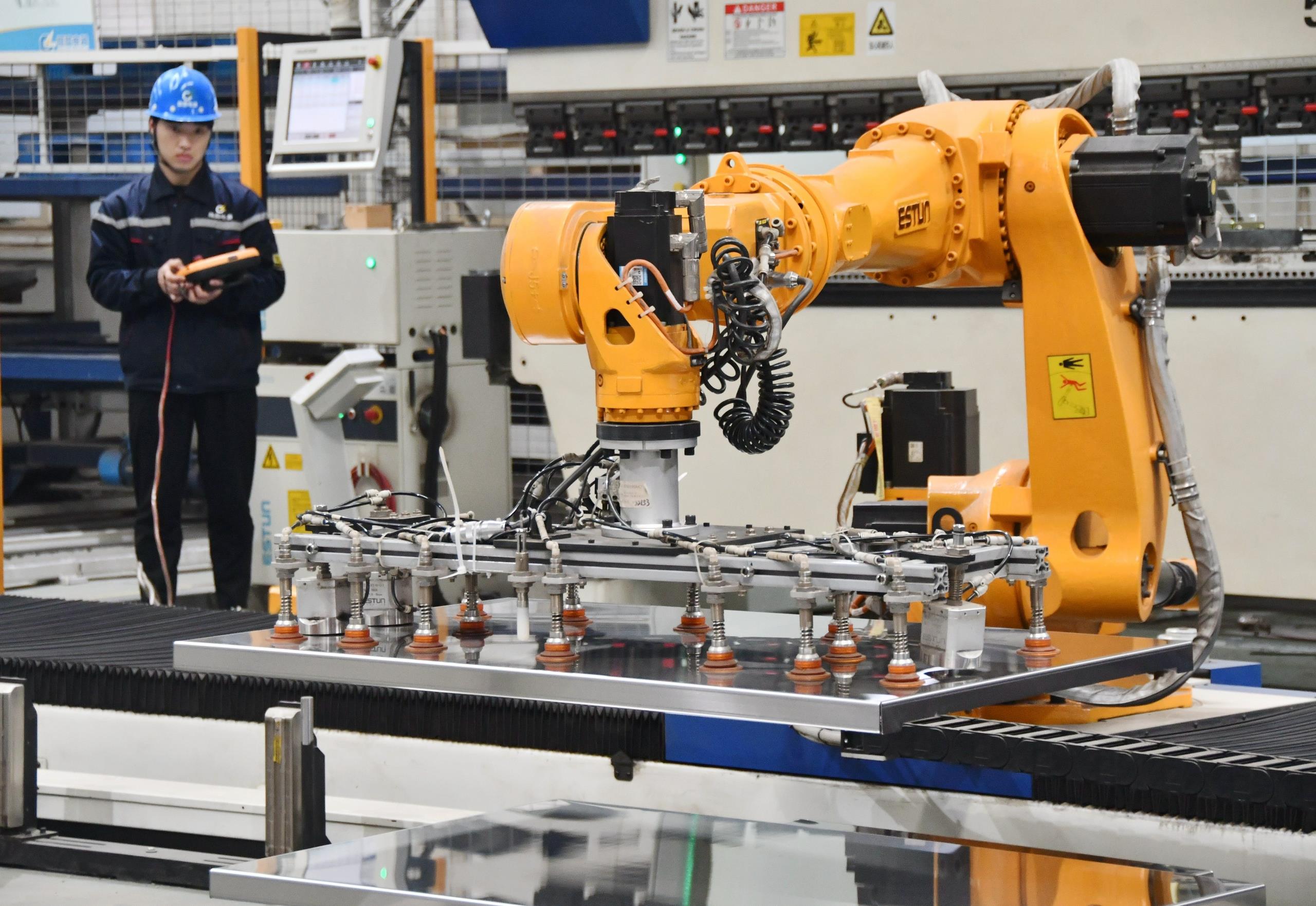 △2025年2月21日，河北邯鄲永年區(qū)工業(yè)園區(qū)的一家企業(yè)，工人正在操控工業(yè)機器人作業(yè)。