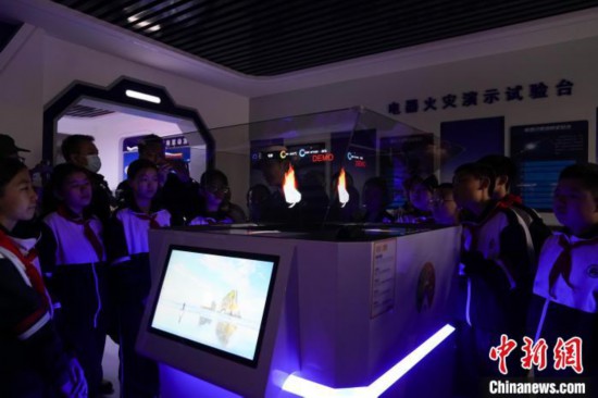 圖為學生們參觀道里區(qū)消防救援大隊消防科普體驗館內(nèi)幻影成像燃燒三要素實驗臺。中新社記者 趙宇航 攝