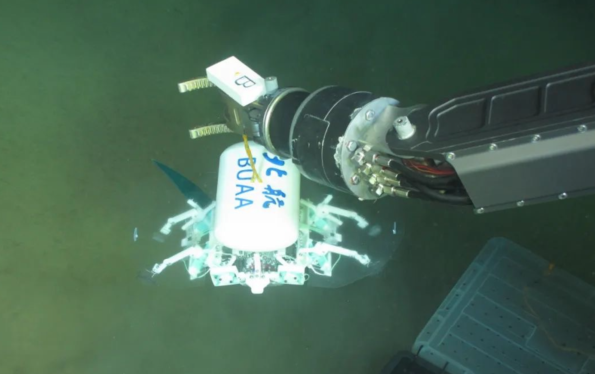 科研人員利用機(jī)械臂將北航深海小型機(jī)器人投于馬里亞納海溝。校方供圖