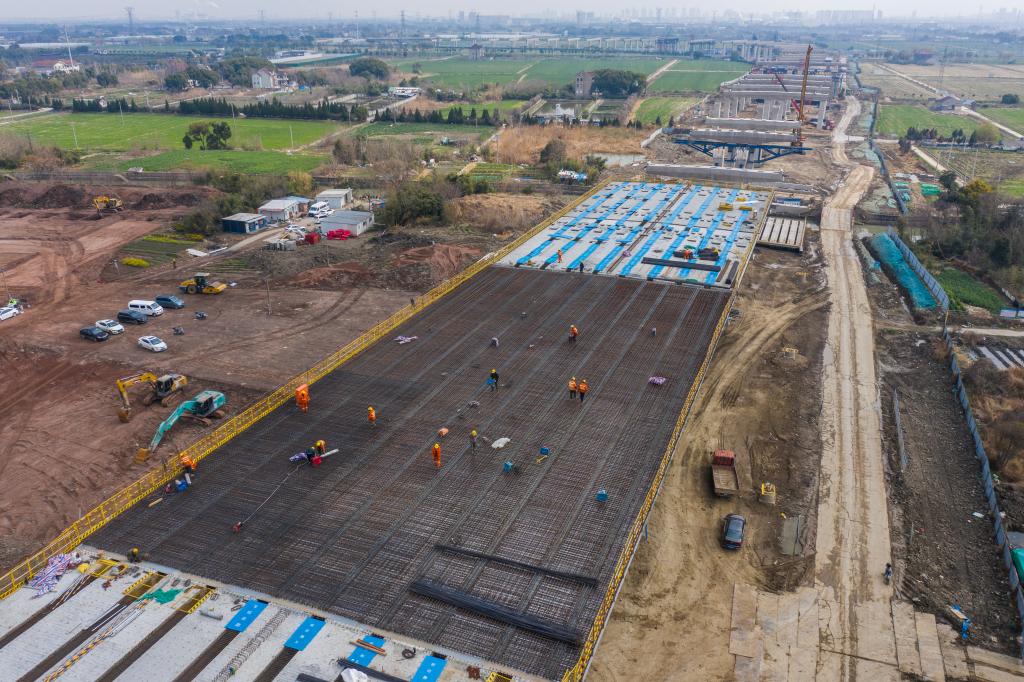 3月7日，在524國道秀洲王江涇至新塍公路工程TJ02標(biāo)段，作業(yè)人員正在進(jìn)行60米鋼混組合梁現(xiàn)澆橋面板鋼筋焊接及綁扎作業(yè)（無人機(jī)照片）。新華社記者 徐昱 攝