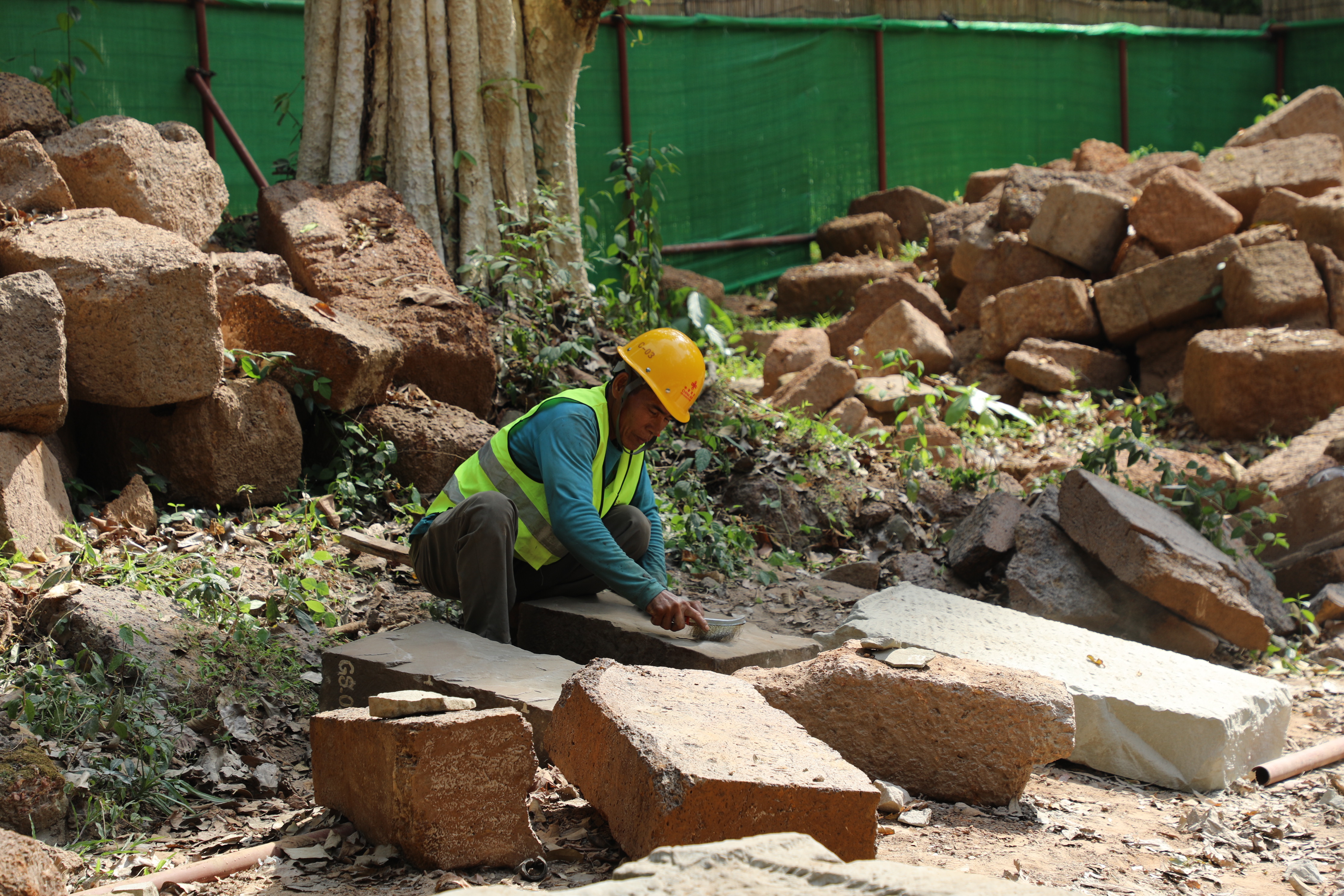 一名柬埔寨工人正在王宮遺址修復(fù)現(xiàn)場(chǎng)工作。（人民日?qǐng)?bào)記者曹師韻 攝）