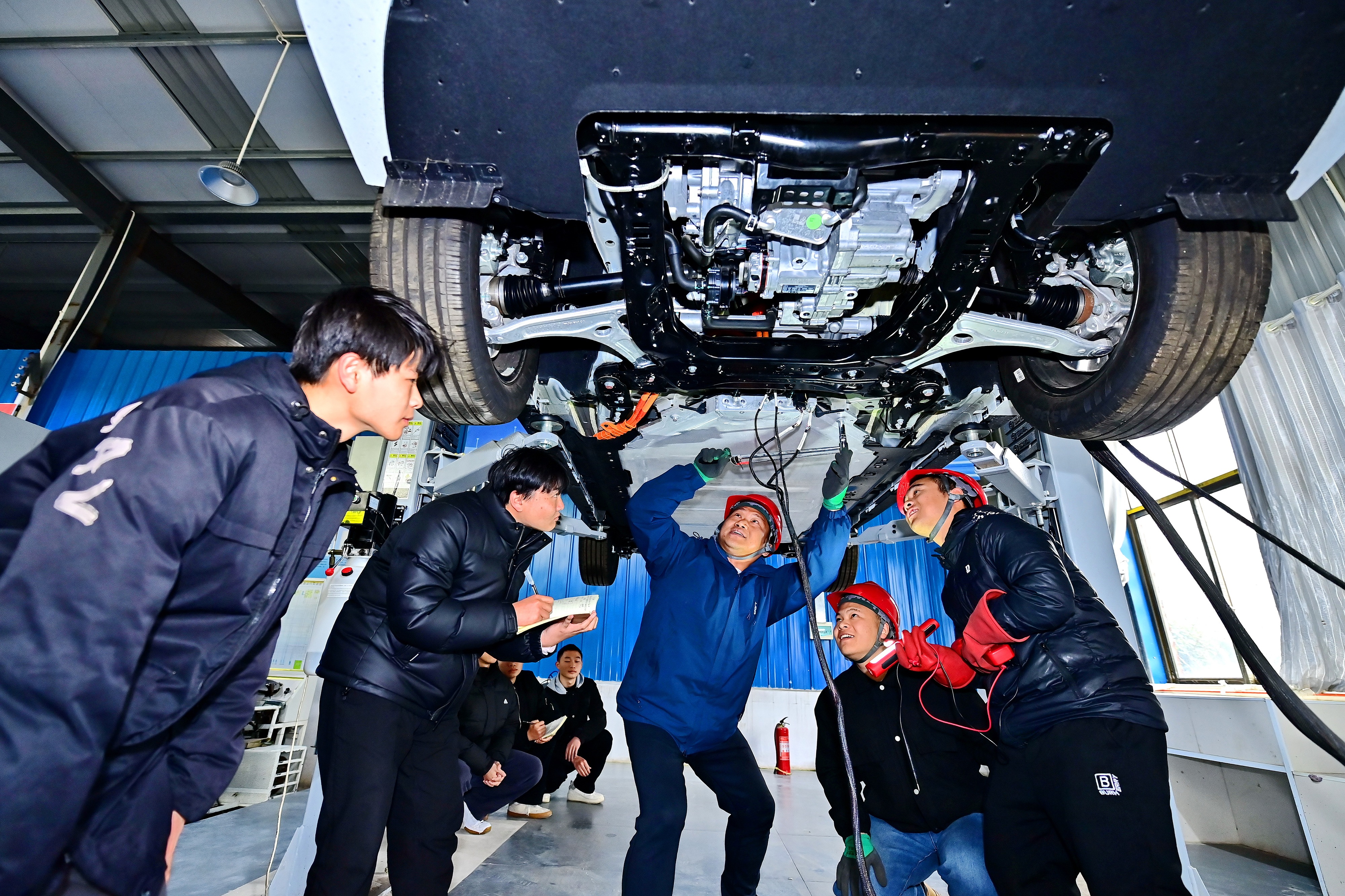 2025年2月，江西省宜春市，豐城市的一所技工學(xué)校實(shí)訓(xùn)基地內(nèi)，新能源汽車運(yùn)維專業(yè)學(xué)生在老師的指導(dǎo)下學(xué)習(xí)新能源汽車電池包檢修技術(shù)。