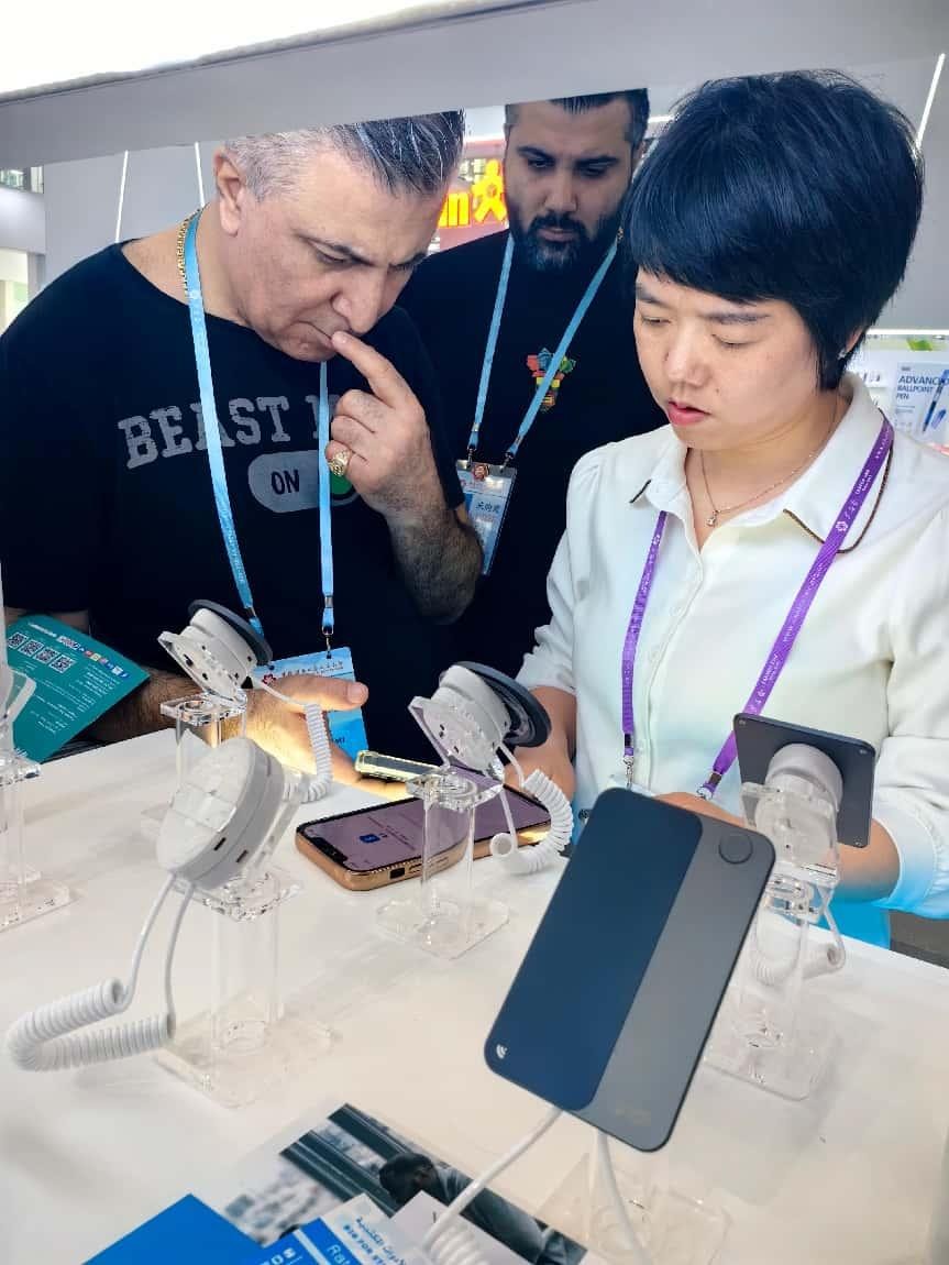 展臺(tái)工作人員向外商展示“AI TOP翻譯終端”。圖片來(lái)源：受訪者提供