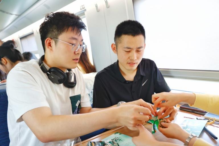 G232次旅客親手制作端午荷包和五彩繩。王磊攝