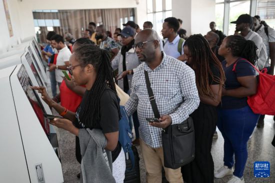 5月31日，在蒙內(nèi)鐵路內(nèi)羅畢站，乘客在自助取票機(jī)前排隊(duì)取票。新華社記者 楊光 攝